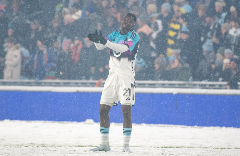 A picture of MNUFC forward Bongokuhle Hlongwane, standing in the snow during MNUFC's 2023 home opener.